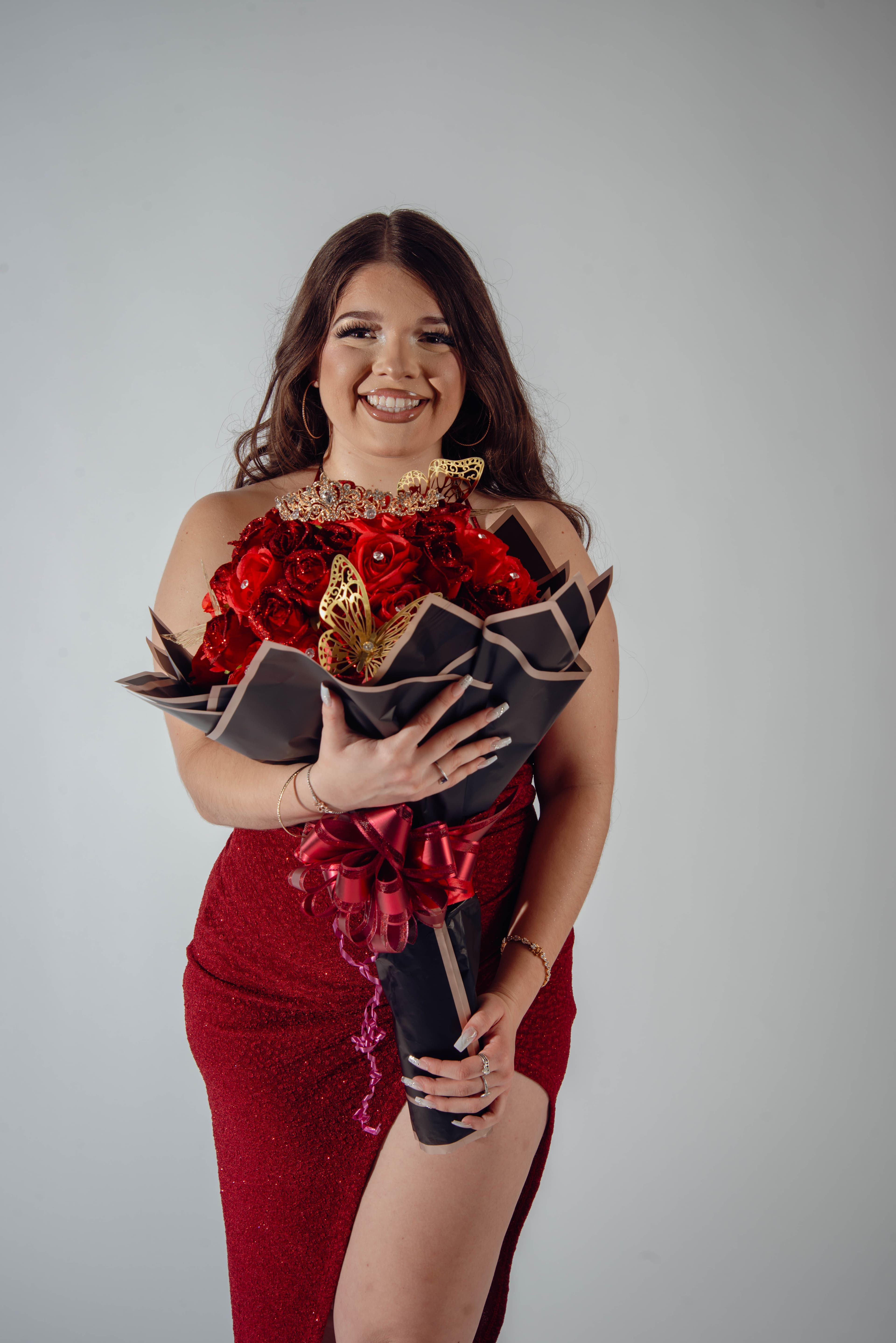 Birthday portrait holding rose bouquet in red sequin gown