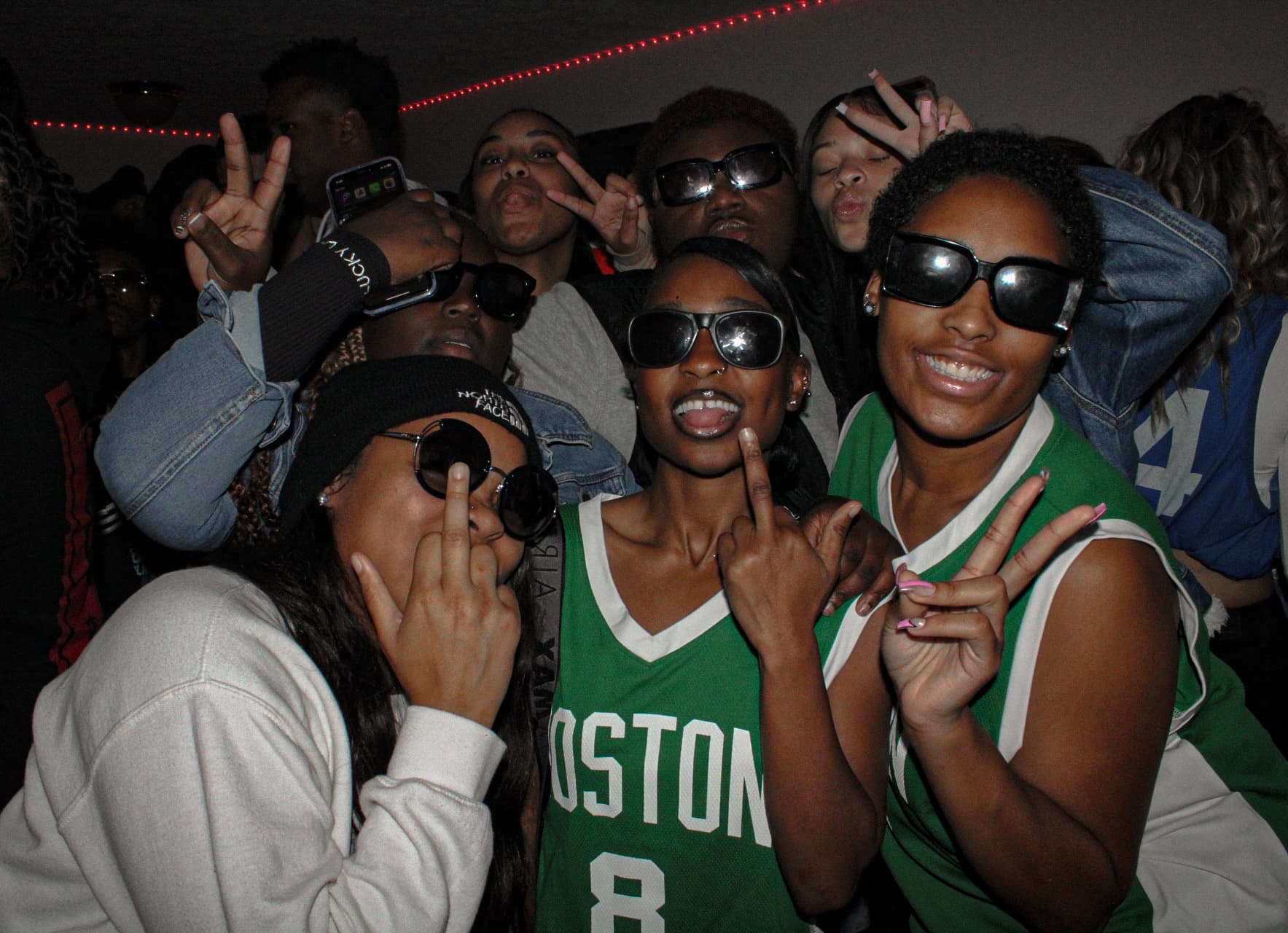 Group of friends posing with sunglasses at a party