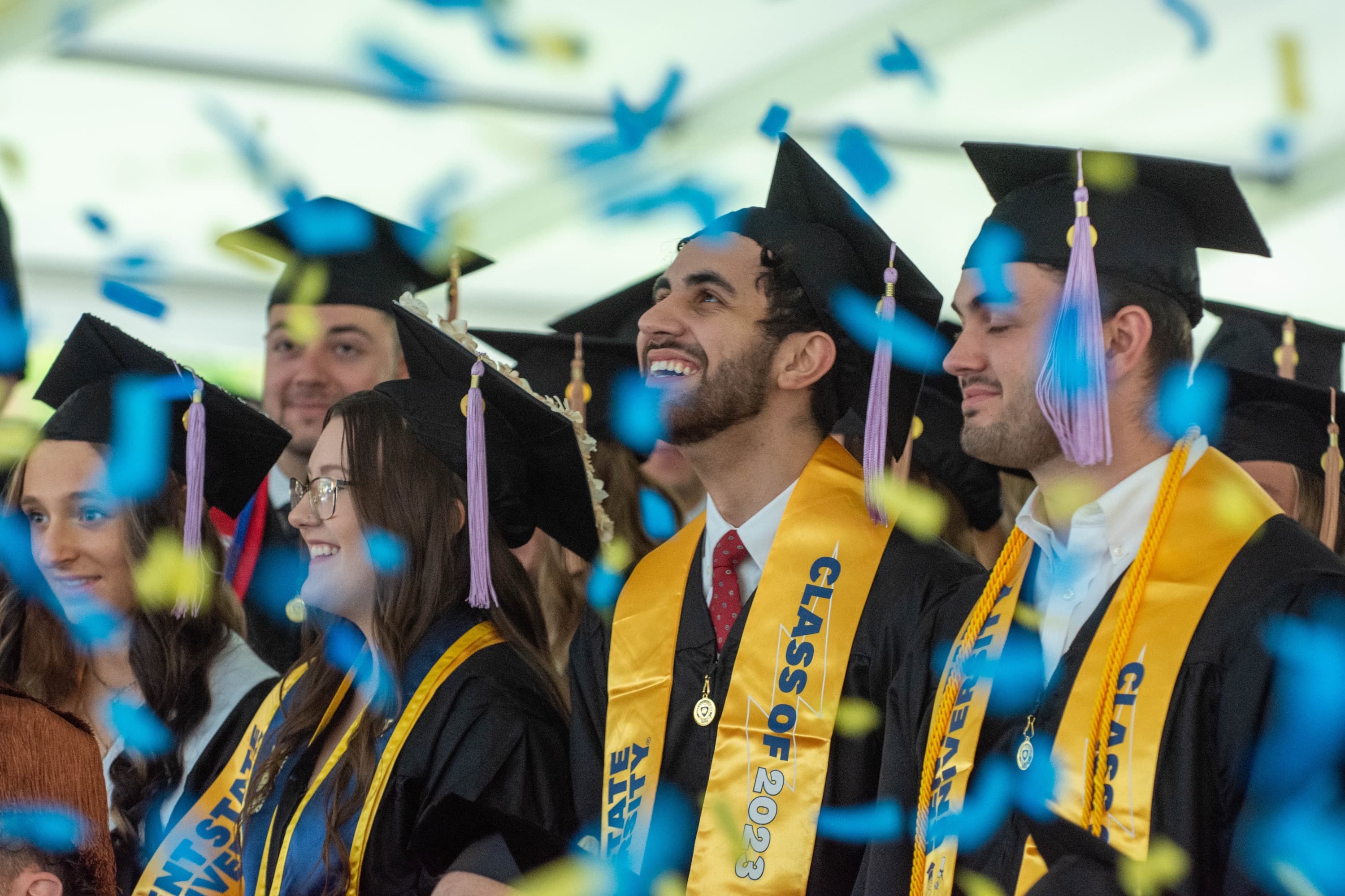 Kent State graduation ceremony with confetti and students in cap and gown